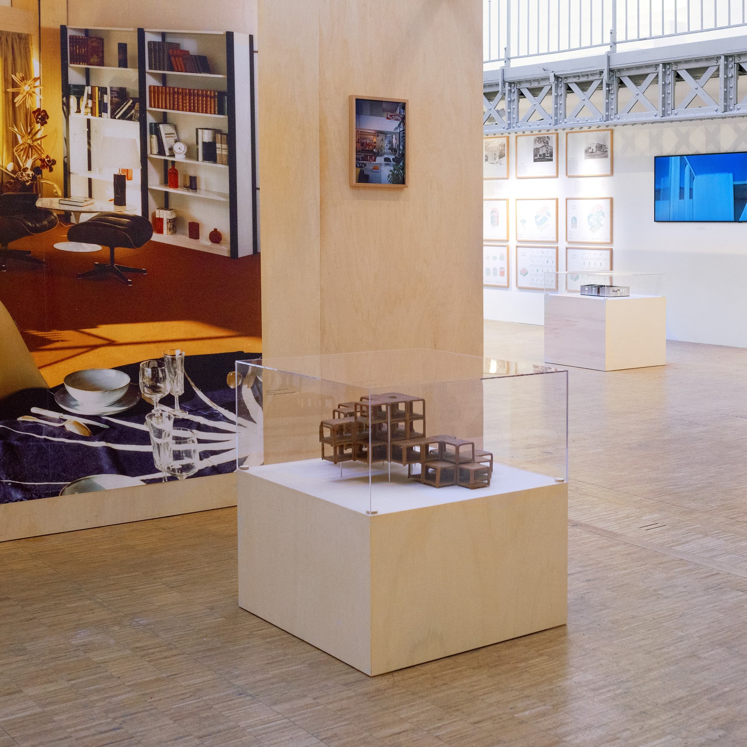 Vue d'une maquette au premier plan, et d'une grande image d'intérieur contrecollée sur une paroi